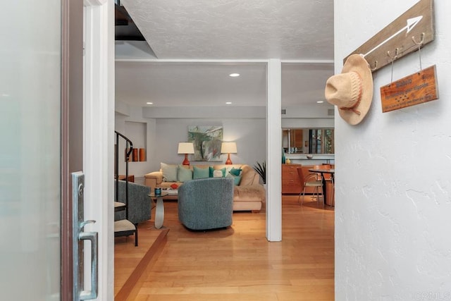 living room featuring wood-type flooring and a textured ceiling