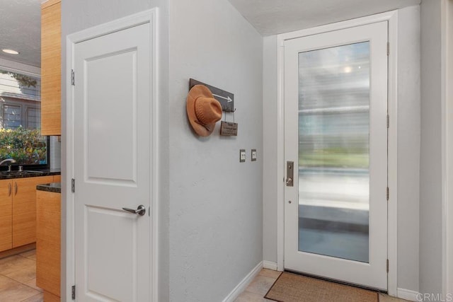 doorway to outside featuring sink, elevator, and light tile patterned flooring