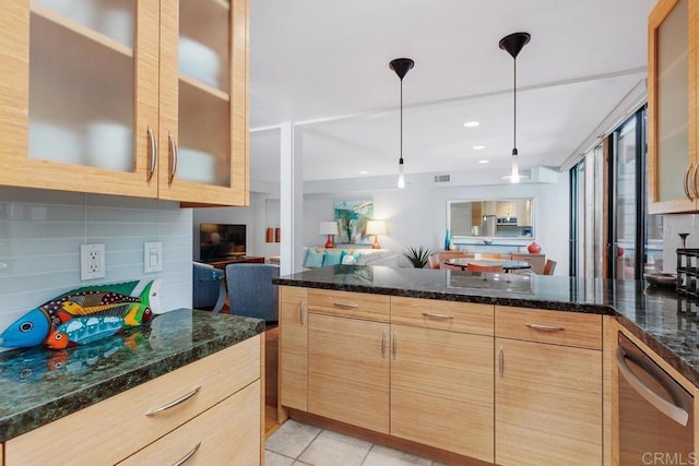 kitchen with pendant lighting, light brown cabinets, dark stone countertops, and backsplash