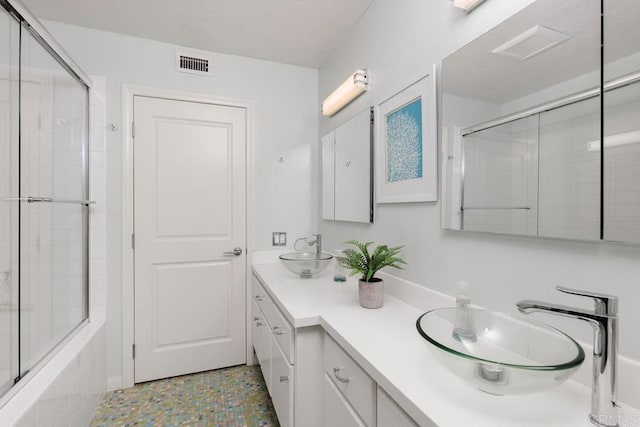 bathroom with vanity and bath / shower combo with glass door