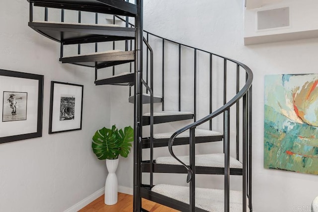 stairs featuring hardwood / wood-style floors