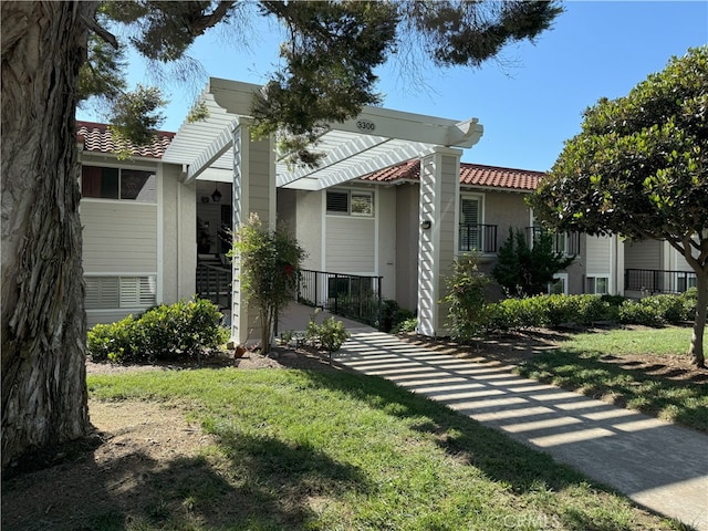 view of front of home featuring a pergola and a front yard