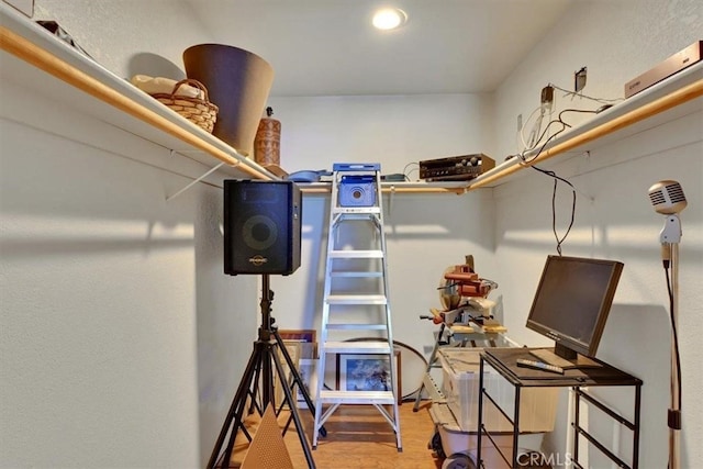 walk in closet with light hardwood / wood-style flooring