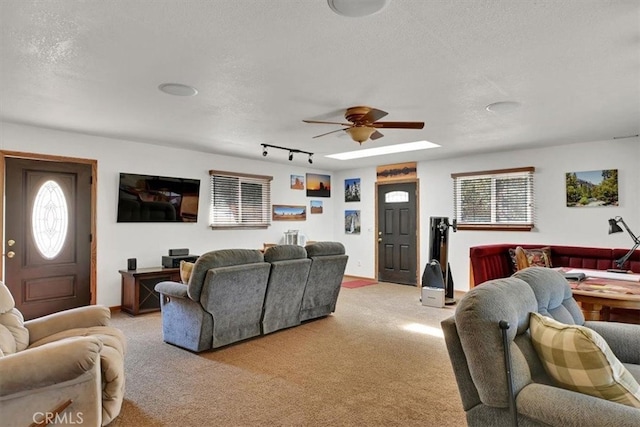 carpeted living room featuring ceiling fan, a textured ceiling, and track lighting