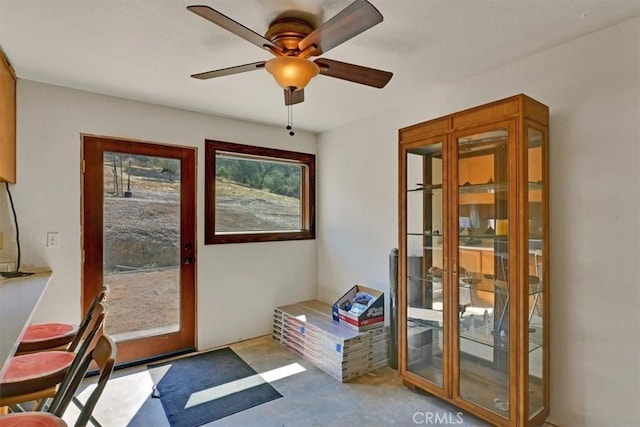 doorway featuring ceiling fan, concrete flooring, and a healthy amount of sunlight