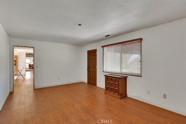 spare room with hardwood / wood-style flooring and a textured ceiling