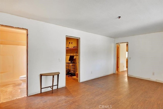 spare room featuring wood-type flooring and a textured ceiling