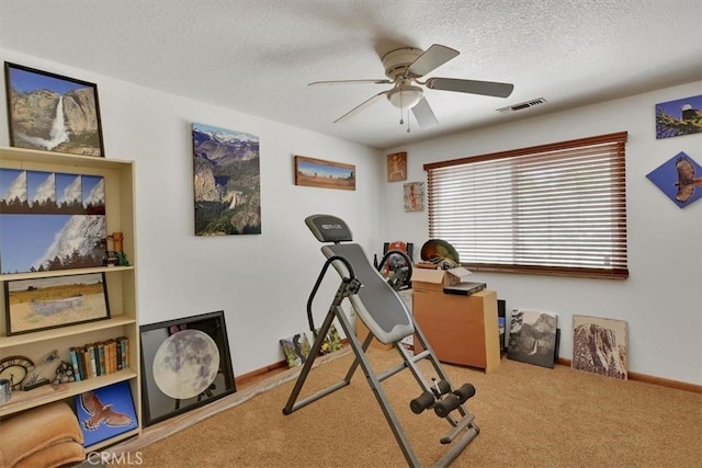 exercise area with ceiling fan, a textured ceiling, and carpet