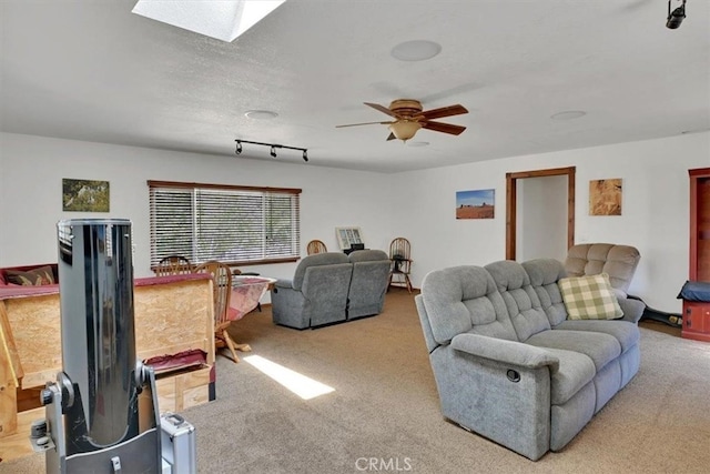 living room with a textured ceiling, carpet, ceiling fan, and a skylight