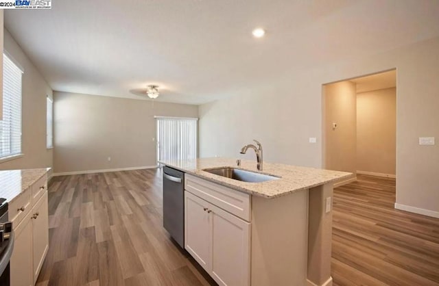 kitchen with white cabinets, sink, stainless steel dishwasher, a kitchen island with sink, and light hardwood / wood-style floors