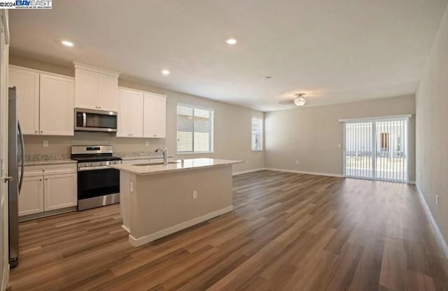 kitchen with a kitchen island with sink, appliances with stainless steel finishes, dark hardwood / wood-style floors, and white cabinetry