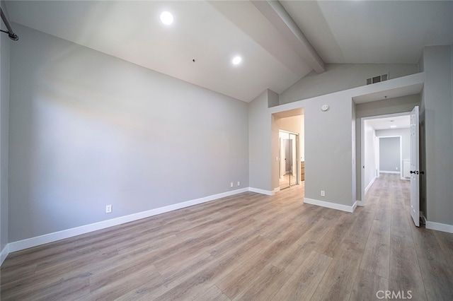 empty room featuring light hardwood / wood-style floors and lofted ceiling with beams