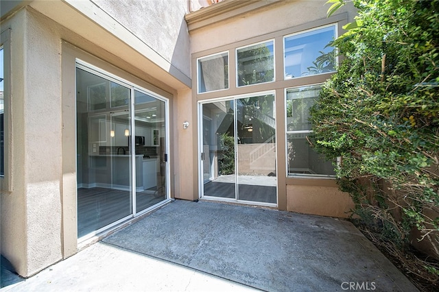 view of exterior entry featuring a patio area