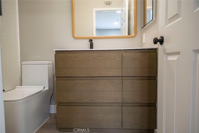 bathroom featuring vanity, hardwood / wood-style flooring, and toilet