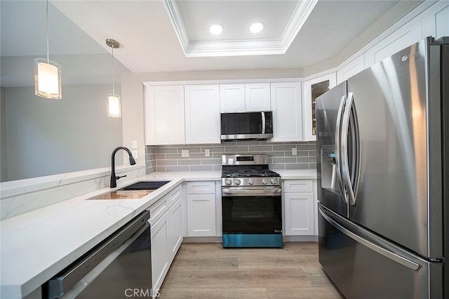 kitchen with white cabinetry, light hardwood / wood-style flooring, sink, pendant lighting, and stainless steel appliances