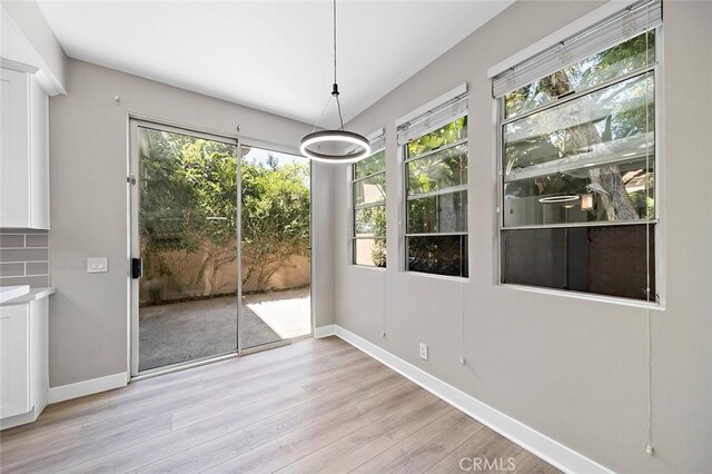 unfurnished dining area with light hardwood / wood-style flooring and a healthy amount of sunlight