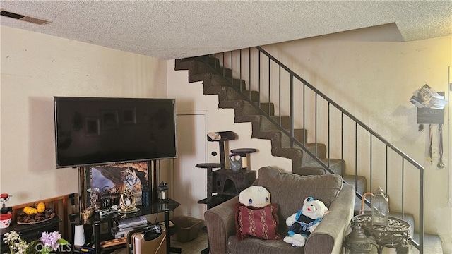 stairs featuring a textured ceiling