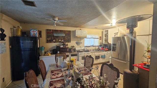 kitchen featuring black appliances, light tile patterned floors, white cabinets, a textured ceiling, and ceiling fan