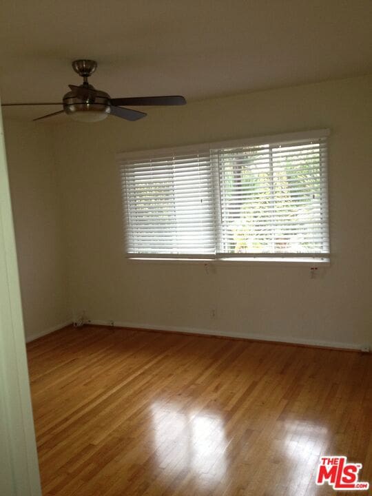 empty room featuring ceiling fan and hardwood / wood-style floors