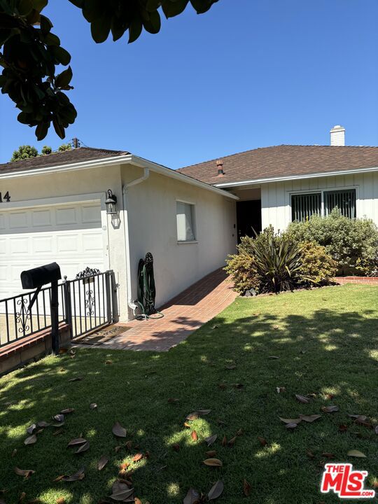 single story home with a front yard and a garage