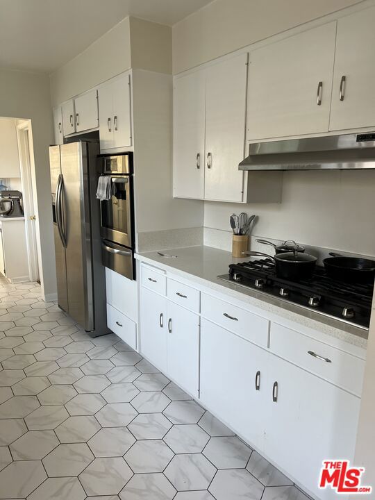 kitchen featuring stainless steel appliances and white cabinets