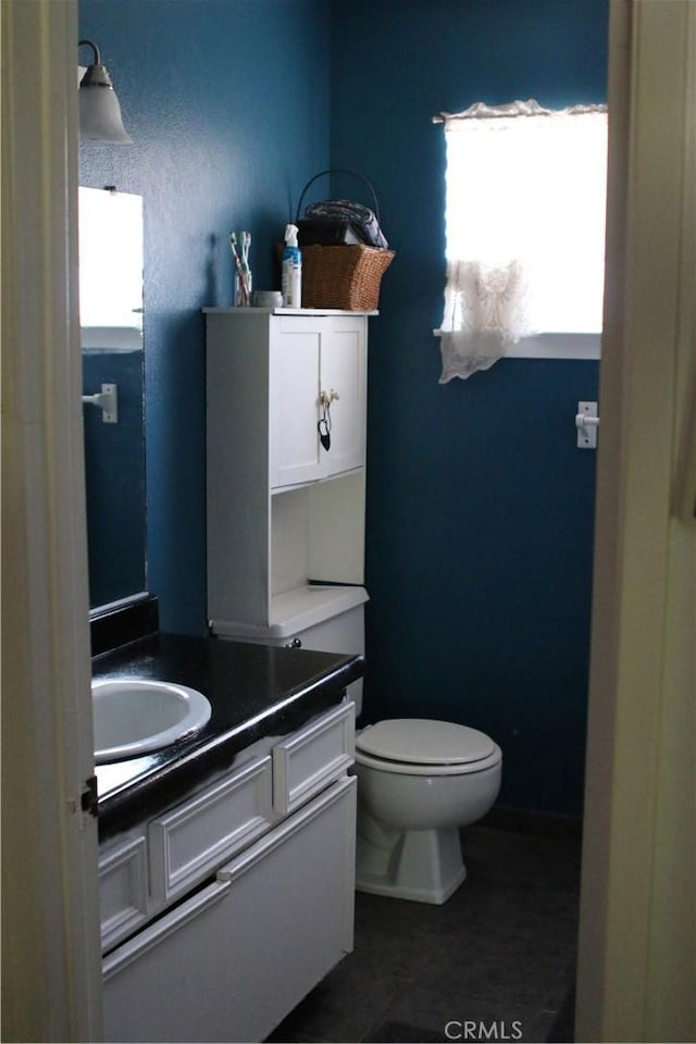 bathroom featuring tile patterned flooring, vanity, and toilet