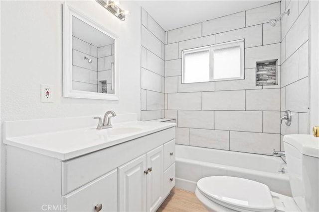 full bathroom with vanity, toilet, and tiled shower / bath combo