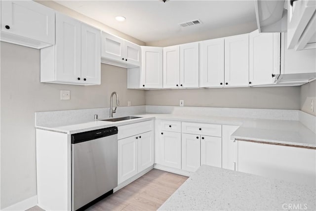 kitchen featuring dishwasher, sink, light stone counters, light hardwood / wood-style floors, and white cabinets