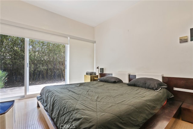 bedroom with access to outside, multiple windows, and vaulted ceiling