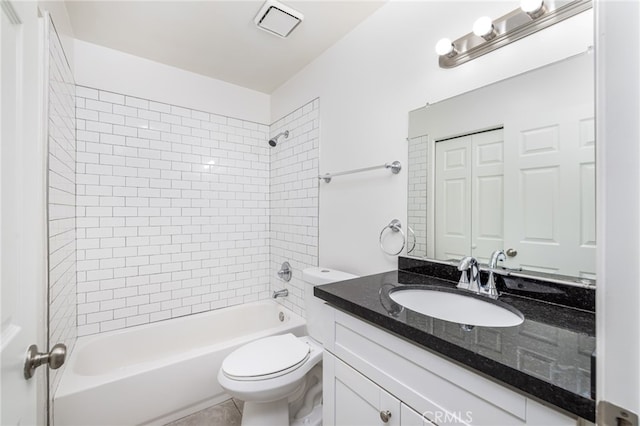 full bathroom with tiled shower / bath, vanity, and toilet