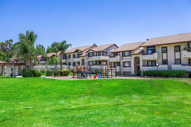 view of home's community featuring a playground and a yard