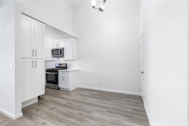 kitchen featuring light hardwood / wood-style flooring, white cabinets, and appliances with stainless steel finishes