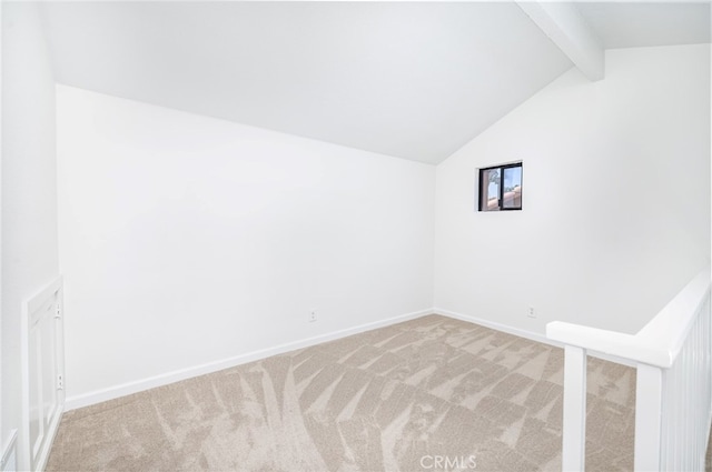 spare room featuring vaulted ceiling with beams and carpet