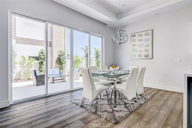 dining room featuring a wealth of natural light, an inviting chandelier, and hardwood / wood-style flooring