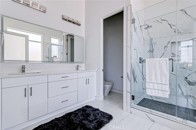 bathroom featuring vanity, toilet, and an enclosed shower