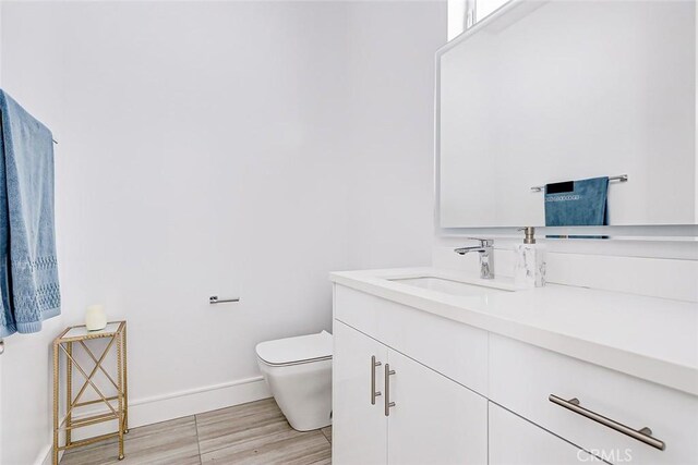 bathroom featuring hardwood / wood-style floors, vanity, and toilet