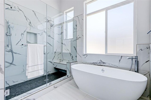 bathroom with tile walls and independent shower and bath