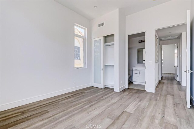 unfurnished bedroom featuring a closet and light wood-type flooring