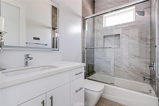 full bathroom featuring vanity, toilet, and enclosed tub / shower combo