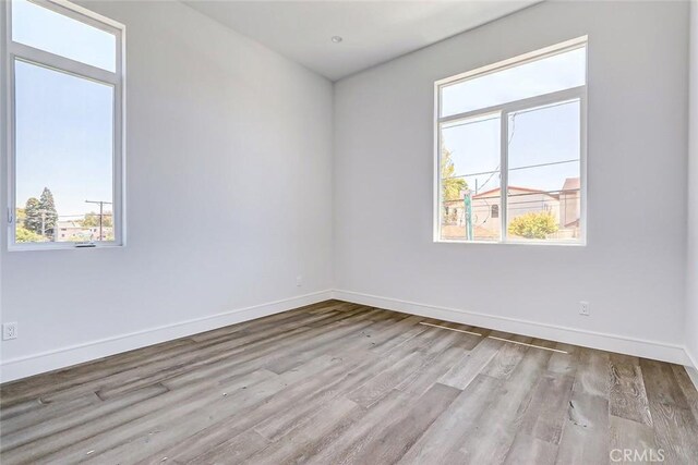 unfurnished room featuring light hardwood / wood-style floors and a healthy amount of sunlight