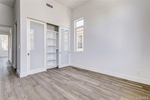 unfurnished bedroom with light wood-type flooring and a closet