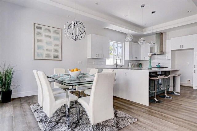 dining space with an inviting chandelier and light hardwood / wood-style flooring