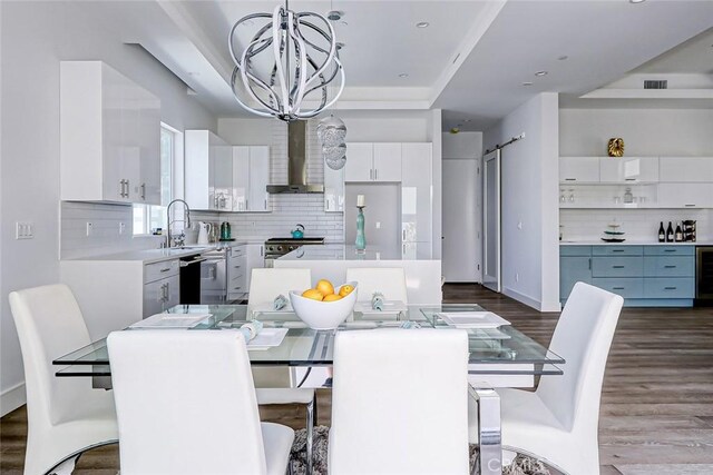 dining space featuring a notable chandelier, dark hardwood / wood-style flooring, sink, and wine cooler