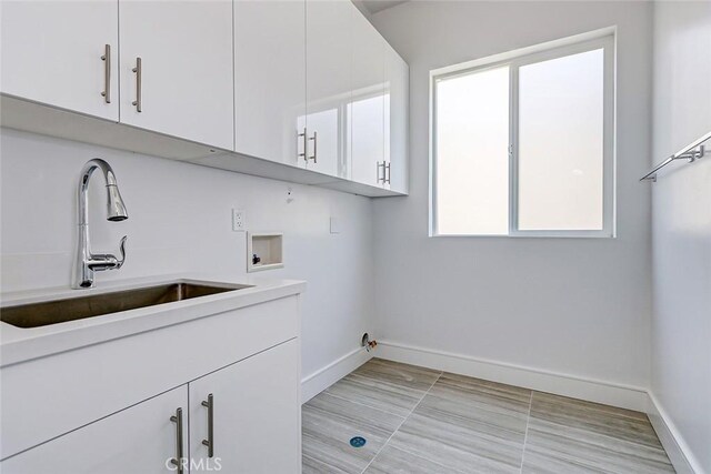 laundry room featuring hookup for a washing machine, sink, and cabinets