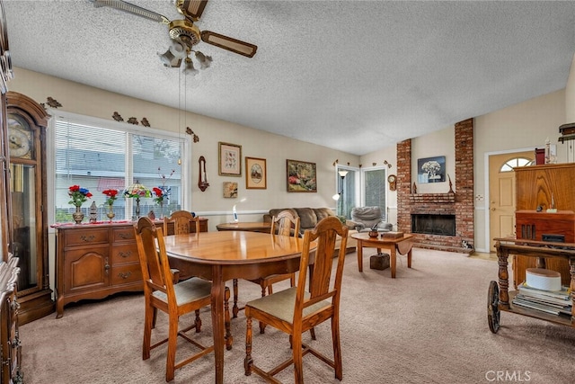 dining area with a textured ceiling, ceiling fan, and light carpet