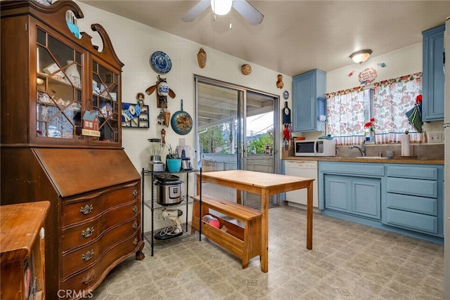 kitchen featuring white appliances, ceiling fan, blue cabinetry, and sink