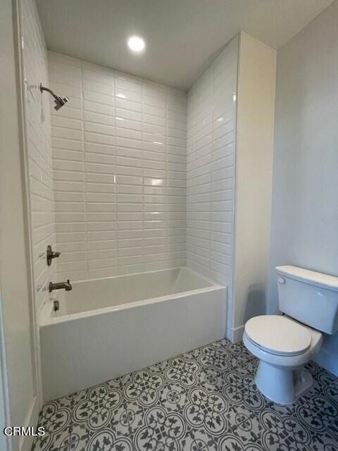 bathroom with tiled shower / bath combo and toilet