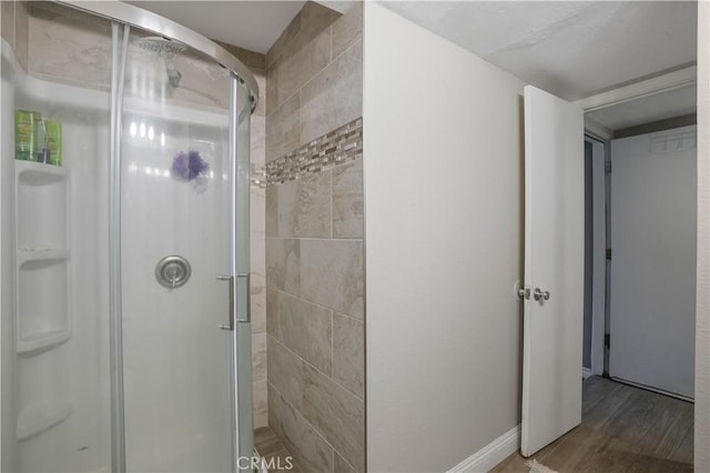 bathroom featuring hardwood / wood-style flooring and a shower with door