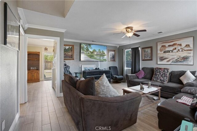 living room featuring light hardwood / wood-style flooring, ceiling fan, and ornamental molding