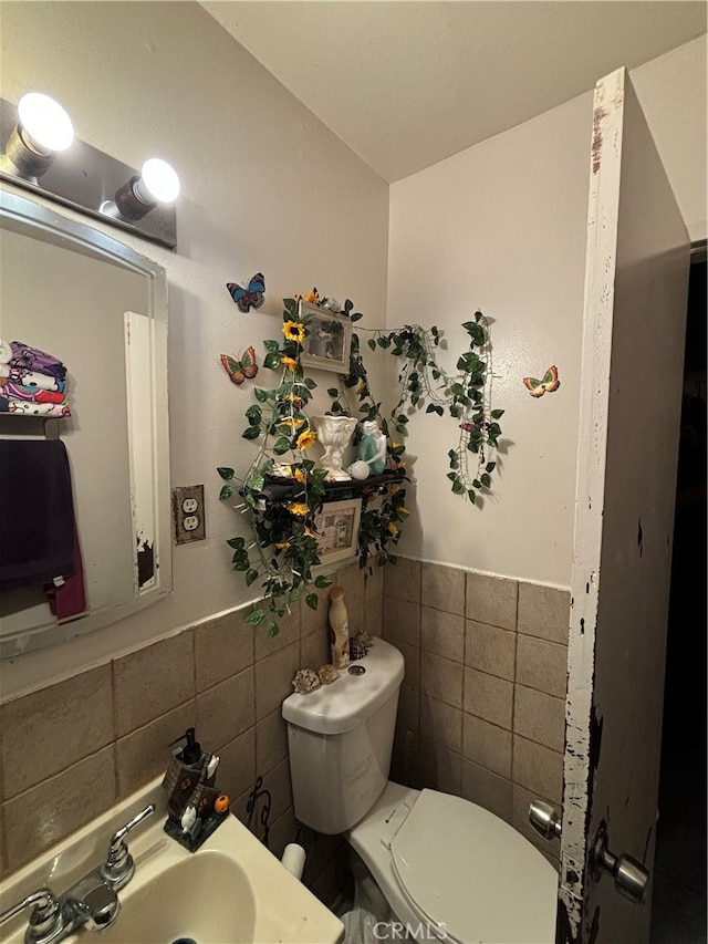 bathroom with tile walls, sink, and toilet